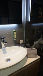 a white sink in a bathroom with a mirror at Maurers Schlierseetraum 6, Studio 455 mit 42 qm neu renoviert, Erdgeschoss mit eingezäunter Terrasse in ruhiger Lage am Kirchbichlweg 8 in Schliersee