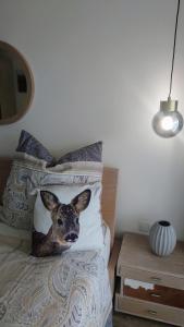 un cane seduto su un letto in una camera da letto di Maurers Schlierseetraum 6, Studio 455 mit 42 qm neu renoviert, Erdgeschoss mit eingezäunter Terrasse in ruhiger Lage am Kirchbichlweg 8 a Schliersee