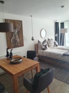 een woonkamer met een tafel en een bed bij Maurers Schlierseetraum 6, Studio 455 mit 42 qm neu renoviert, Erdgeschoss mit eingezäunter Terrasse in ruhiger Lage am Kirchbichlweg 8 in Schliersee