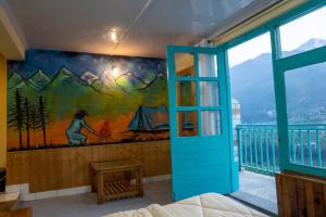 a bedroom with a mural on the wall at The Vagabond Manali in Manāli