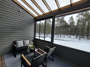 una veranda riparata con tavolo e sedie di Jäkälätie Apartments by Hiekka Booking a Kalajoki
