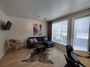 a living room with a couch and a table at Jäkälätie Apartments by Hiekka Booking in Kalajoki