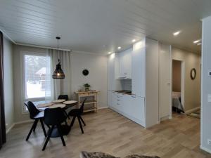 una cucina e una sala da pranzo con tavolo e sedie di Jäkälätie Apartments by Hiekka Booking a Kalajoki