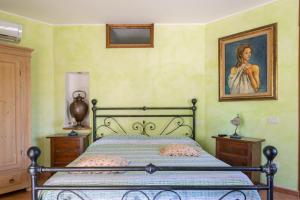 1 dormitorio con 1 cama con una pintura en la pared en Flores, en Roccastrada