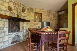 uma cozinha com uma mesa e uma parede de pedra em Flores em Roccastrada