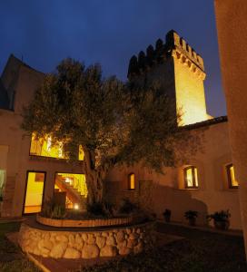 un edificio con un árbol delante de él en Torre del Prior en Tortosa