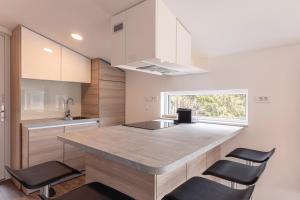 a kitchen with a large island with black chairs at Chalets & Glamping Nassfeld by ALPS RESORTS in Kötschach