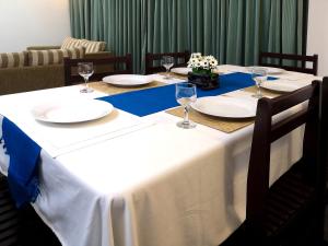 a table with plates and wine glasses on it at Great Location Living, Modern 2-Bed Apartment with Pool & Gym Access, All Amenities in Sri Jayewardenepura Kotte