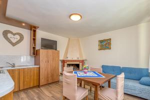 a kitchen and living room with a table and a blue couch at Apartment Flores in Stari Pazin