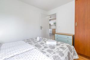 um quarto branco com uma cama e um armário de madeira em Zea em Funtana