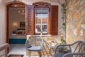 a patio with two chairs and a table and a window at Esperides Studios in Syvota