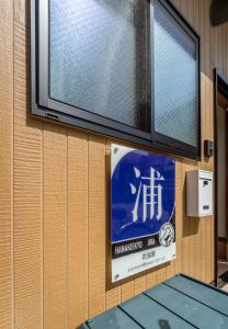 a sign on the side of a building with a window at HANASTAY花渓居 · 浦（URA) in Osaka