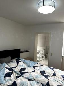 ein Schlafzimmer mit einem Bett mit einer Decke darauf in der Unterkunft Mühlengässchen Continental in Krefeld