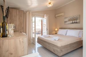 a bedroom with a bed and a bottle of wine at Esperides Studios in Syvota