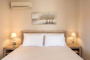 a bedroom with a bed with two night stands and two lamps at Esperides Studios-Seaside Stay with View in Syvota in Syvota +29 photos