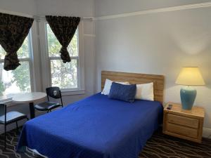 a bedroom with a blue bed and a table and chairs at Twin Peaks Hotel in San Francisco