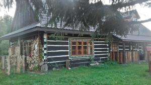 a black house with a tree in front of it at Horpyna in Krempna