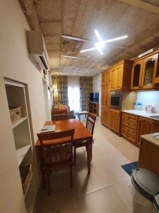 una cocina con mesa de madera y sillas. en B&S Accommodation Apartment 601, en Hal Ghaxiak