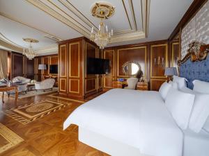 1 dormitorio con 1 cama y sala de estar en Rixos Khadisha Shymkent, en Shymkent