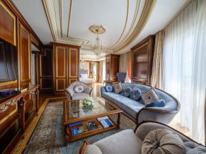 a living room with a couch and a table at Rixos Khadisha Shymkent in Shymkent