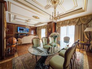 uma sala de estar com uma mesa de vidro e cadeiras em Rixos Khadisha Shymkent em Shymkent