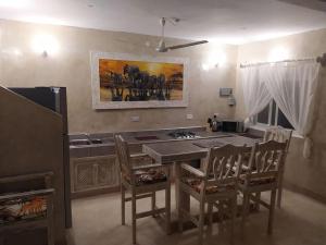 une cuisine avec une table et des chaises ainsi qu'une peinture murale. dans l'établissement Garoda House Turtle Bay [ Jacuzzi ☆☆☆☆☆ ] Kilifi, à Watamu