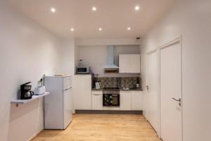 a kitchen with white cabinets and a refrigerator at Charmant Dieppois, 2 chambres, centre ville in Dieppe