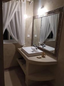 y baño con lavabo y espejo. en Garoda House Turtle Bay [ Jacuzzi ☆☆☆☆☆ ] Kilifi, en Watamu