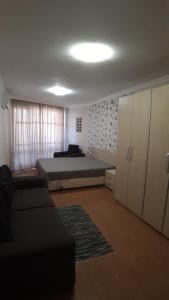 a bedroom with a bed and a couch in a room at Apartament Sarafovo in Burgas City