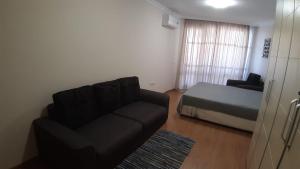 a living room with a couch and a bed at Apartament Sarafovo in Burgas