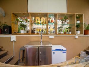 a bar with a sink and a counter with bottles at Verandah - A Beautiful Story, Near Anjuna Beach in Anjuna