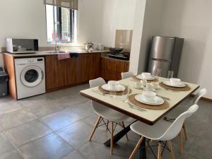a kitchen with a table and chairs in a kitchen at Dragon Nest Apartments in Port Louis