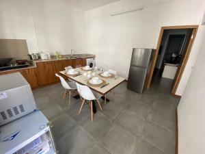 een keuken met een tafel met stoelen en een koelkast bij Dragon Nest Apartments in Port Louis