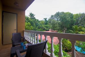 a balcony with a table and chairs and a view at Verandah - A Beautiful Story, Near Anjuna Beach in Anjuna