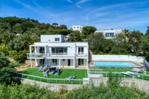 - une vue aérienne sur une maison avec une piscine dans l'établissement Beautiful contemporary villa with sea view, heated swimming pool, near Saint Tropez, à Cavalaire-sur-Mer