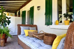 a wicker chair sitting on a porch with baskets at B&B La Locandiera in Castiglione della Pescaia