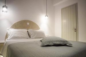 a bedroom with a bed with a pillow and two lights at Casa Borealis in Naxos Chora