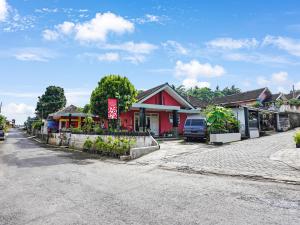 une rue dans une ville avec un bâtiment rouge dans l'établissement OYO Homes 91103 Syariah Desa Wisata Lembah Gunung Tumpeng, à Sumberwaras