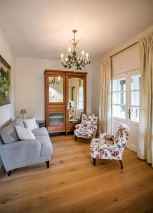 a living room with a couch and two chairs and a chandelier at Villa Rosen der Villa Liechtenstein in Altaussee