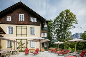 une maison avec une terrasse dotée de chaises et de parasols dans l'établissement Villa Rosen der Villa Liechtenstein, à Altaussee