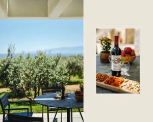 a table with a bottle of wine and a plate of fruit at Casa Del Olivar in Develíkia