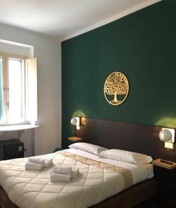 ein Schlafzimmer mit einem großen Bett und einer grünen Wand in der Unterkunft Il Piccolo Albergo Matera in Matera