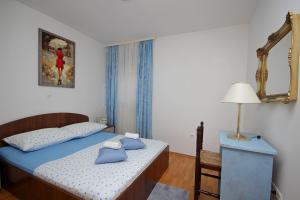 sypialnia z łóżkiem, stołem i lustrem w obiekcie Apartment Marinovic w Makarskiej