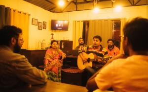 a group of people sitting in a living room playing guitar at Zemu Gangtok in Gangtok
