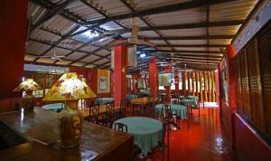 a restaurant with tables and chairs and a lamp on a table at S and K Safari Village Hotel - Wasgamuwa in Wasgamuwa