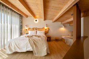 a bedroom with a bed with white sheets and wooden ceilings at Casa Del Olivar in Develíkia +105 photos