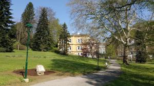 einem grünen Laternenpfahl in einem Park mit einem Gebäude in der Unterkunft Villa Clar im Park in Bad Gleichenberg