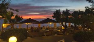 una puesta de sol sobre el agua en un restaurante de playa en Akrogiali, en Kyparissia