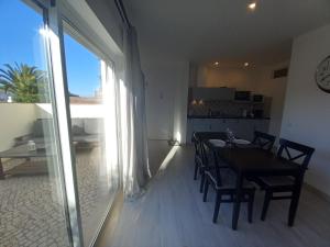 comedor y cocina con mesa y sillas en Lopes Apartment - Belch1952, en Lagos