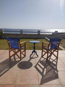 two chairs and a table in front of the beach at Λακεδαιμονία in Paralia Demonias